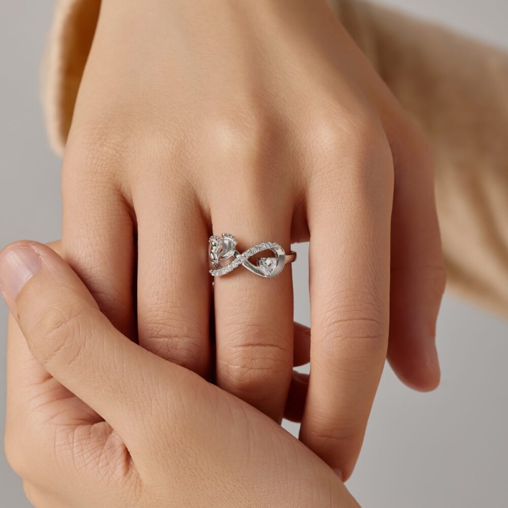 Woman wearing Sterling Silver infinity ring with two baby's feet shape, as a gift for mothers who newly gave birth to a new child